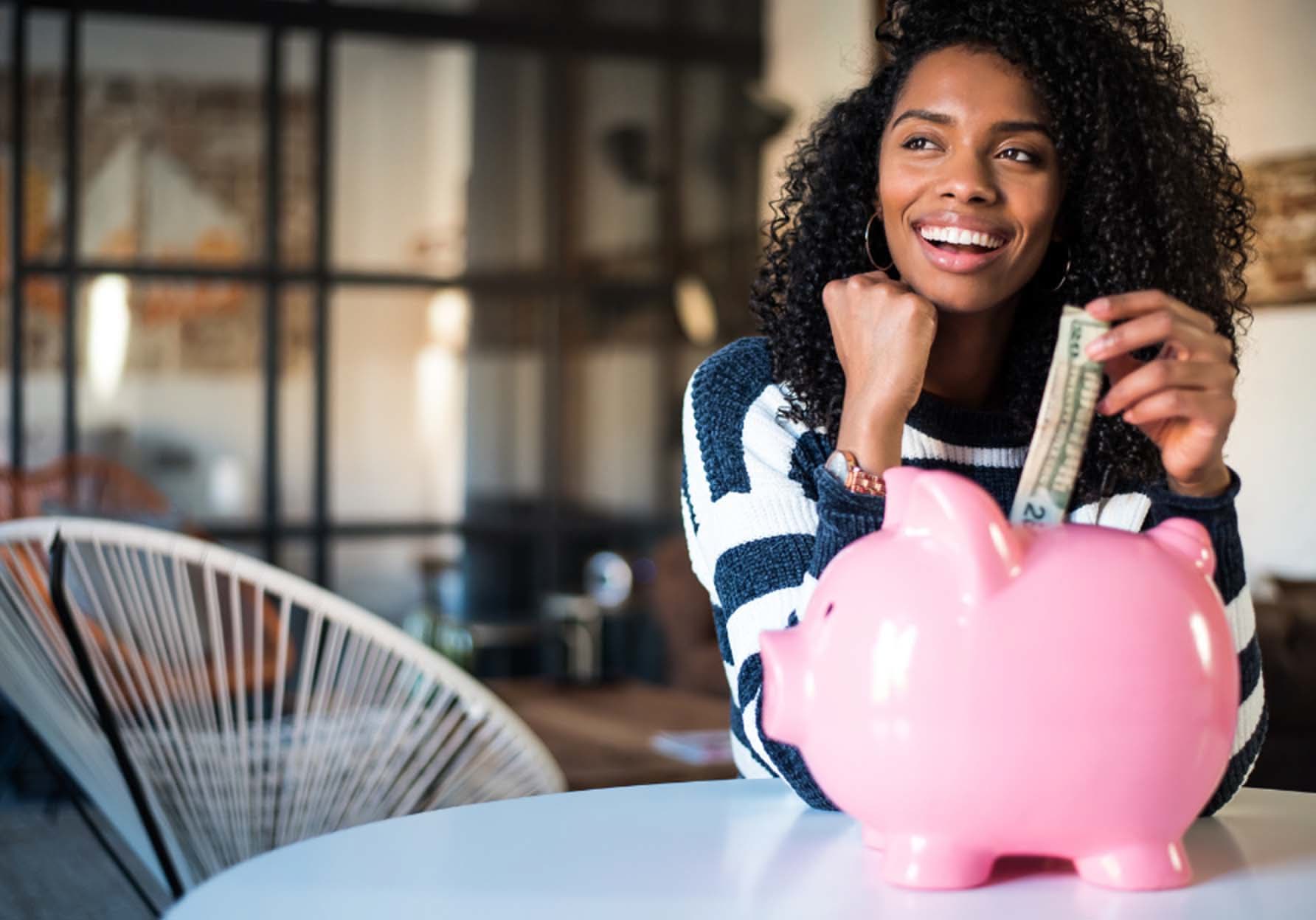Woman putting money into a piggy bank